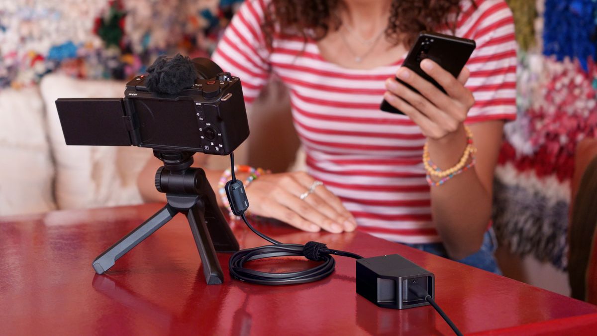 Sony DC-C1 Coupler connected to a camera while a person in a striped shirt films themselves