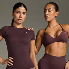 Two female models wearing matching burgundy sets from Oner Active.
