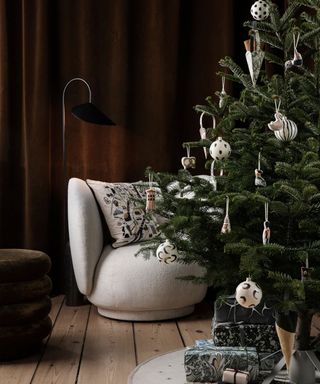 Christmas tree with cozy lounge chair and floor lamp in background