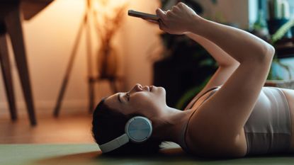 What kind of workout is Pilates? A woman on her phone post exercise