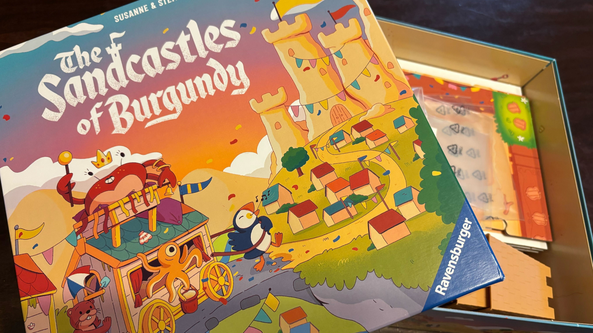 The Sandcastles of Burgundy box, partially opened, on a dark wooden surface