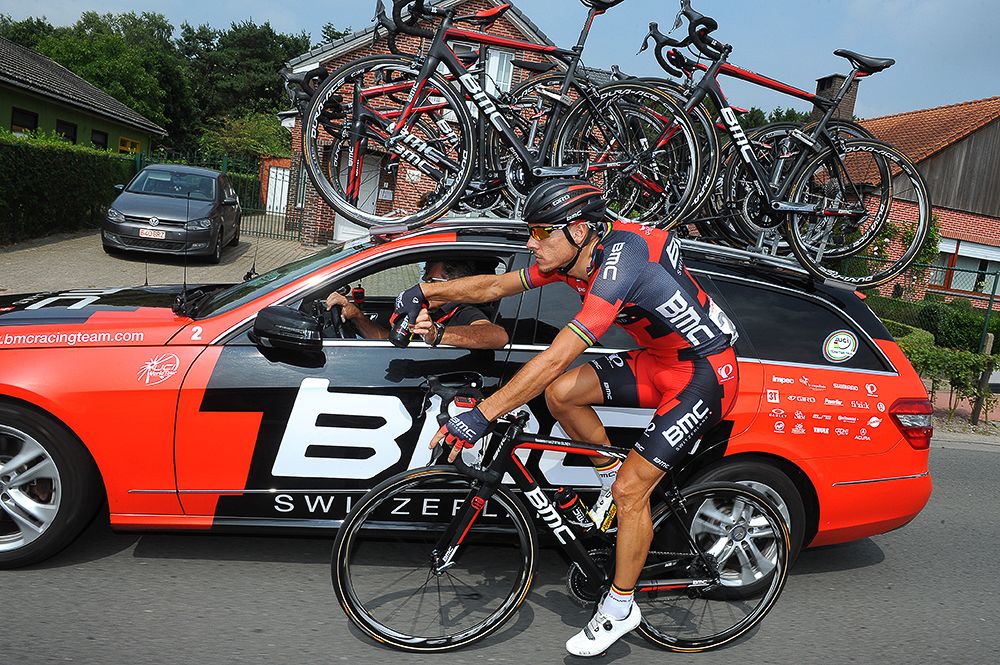 Philippe Gilbert grans some water from the team car.