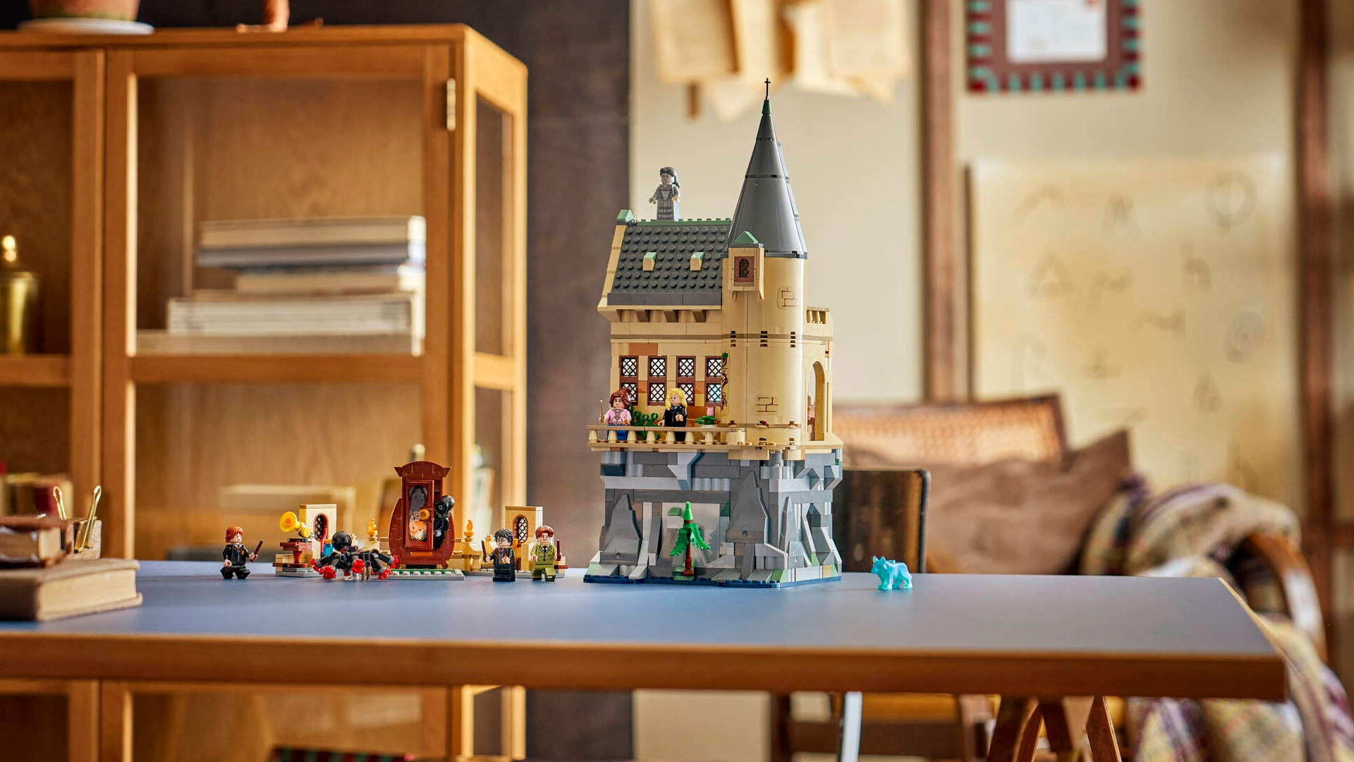 A Lego castle and minifigures, laid out on a wooden table