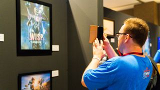 A museum attendee takes a photo of an exhibit