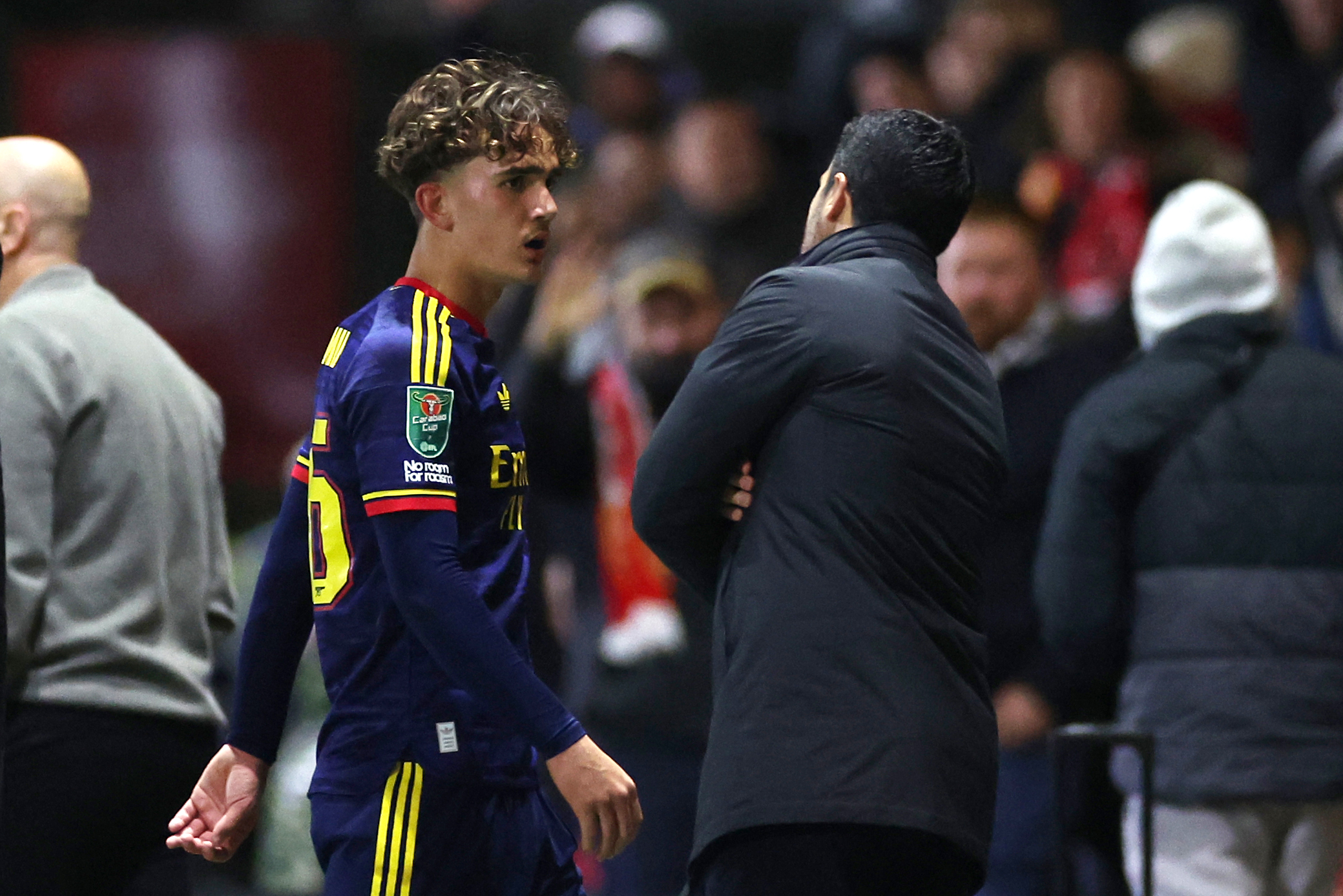 Mikel Arteta, Manager of Arsenal, talks to Max Dowman of Arsenal as he walks off the pitch after being sent off during the Carabao Cup Fourth Round