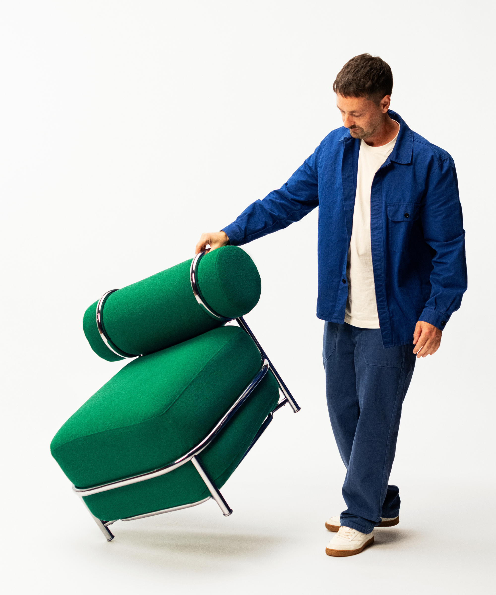 a man balancing a green chair on one leg
