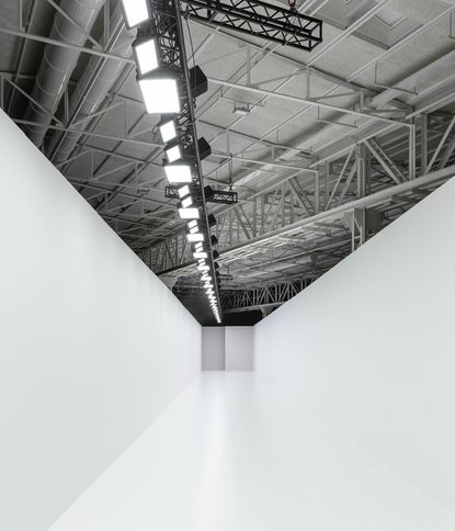 A white walled catwalk with lights above on metal girders