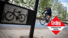 Cyclist rides in London with Commute Week roundel added