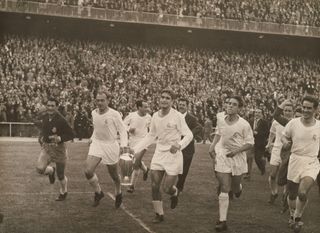 Real Madrid players celebrate with the European Cup after winning the 1957 final against Fiorentina