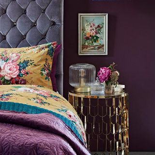 bedroom with violet wall bed with designed cushion and bedside table