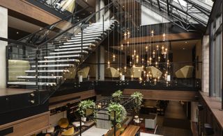Floating staircases and black metal light fixtures in Hotel William Gray