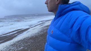 Side view of Fjällräven Expedition Mid Winter Jacket at the beach