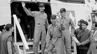 The crewmembers of the Apollo 13 mission step aboard the USS Iwo Jima, after splashdown and recovery operations in the South Pacific Ocean on April 17, 1970. Exiting the helicopter from left to right are Fred Haise, James Lovell and John Swigert. 