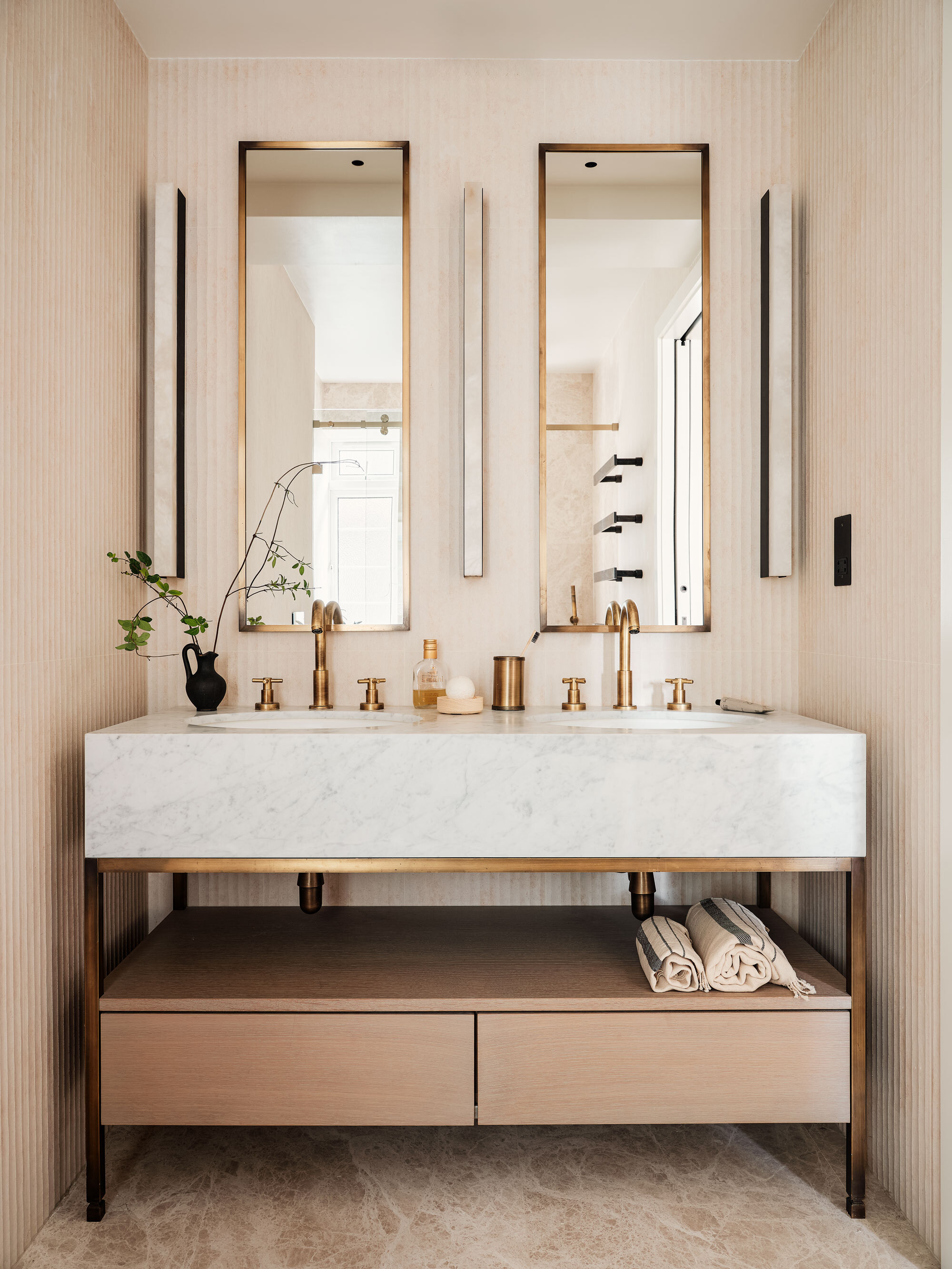 The en suite bathroom, with a double sink and two wall mirrors and marble stonework