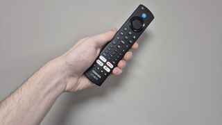 Toshiba 32LF2F53DB remote in person's hand