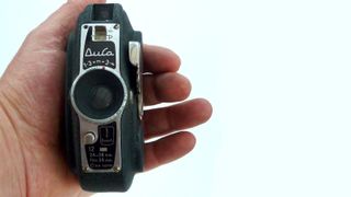A hand holding the Durst Duca camera