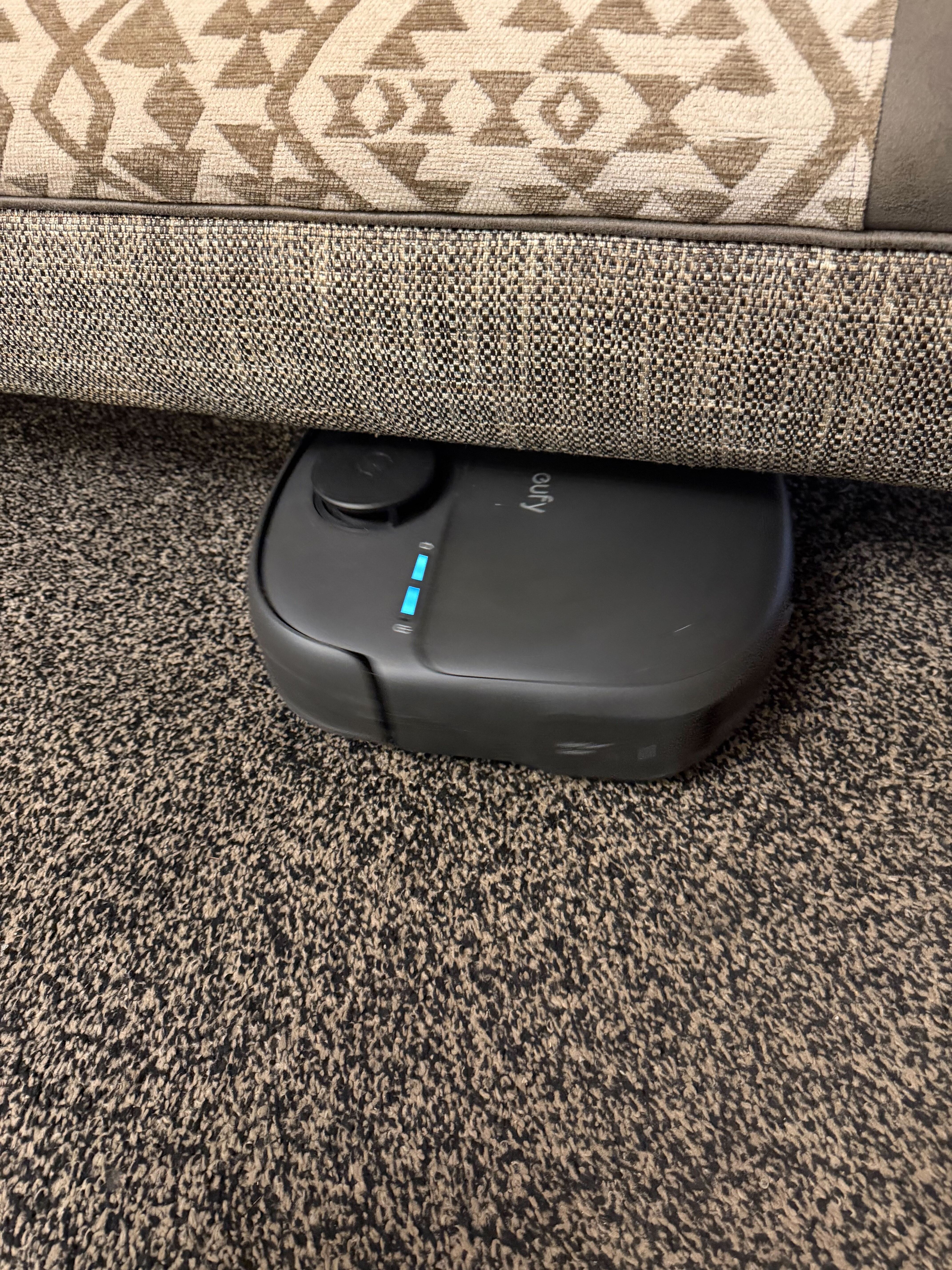 A robovac cleaning under a footstall