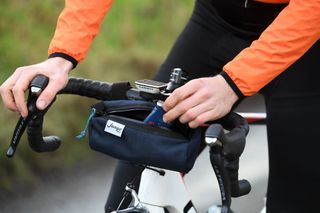 Image shows a rider taking nutrition out of a bar bag