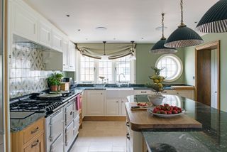 kitchen with blinds and island, white aga and green walls