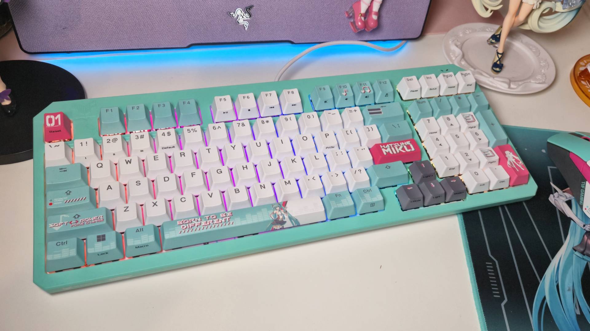 Photo by Rosalie Newcombe of the Asus TUF Gaming Hatsune Miku gaming keyboard sitting on a white desk.