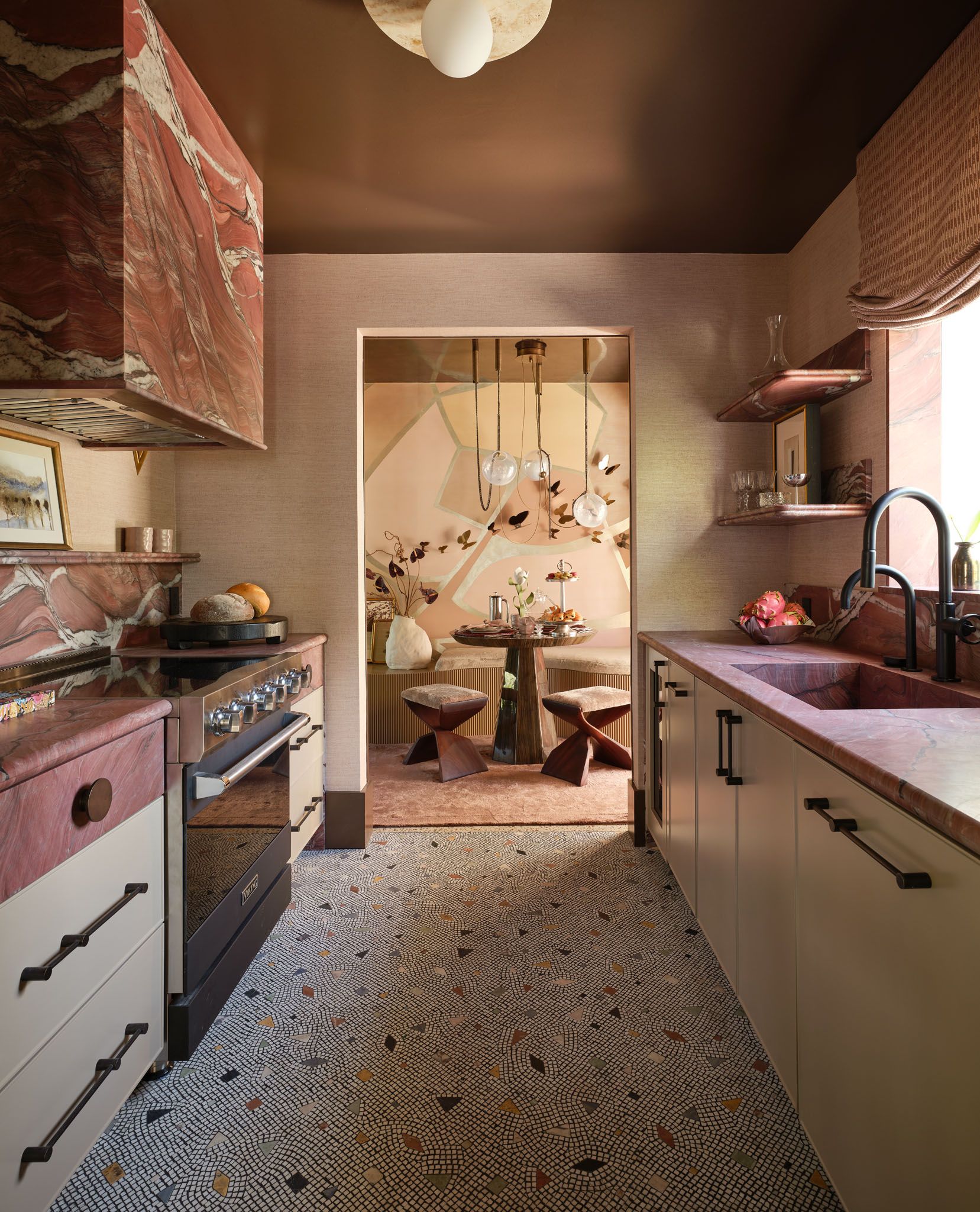 A kitchen at the Kips Bay Decorator Showhouse showing colorful mosaic tiles across the galley floor. 