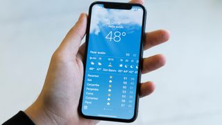 An iPhone with the Weather app open, demonstrating how to enable weather alerts on iPhone