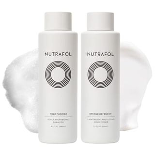 Nutrafol Shampoo and Conditioner bottles side by side on a white background with product splotches 