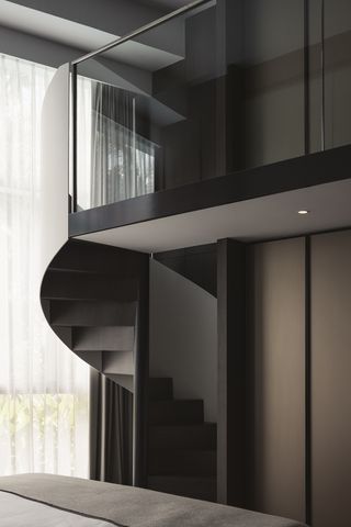 spiral staircase leading to a glass mezzanine