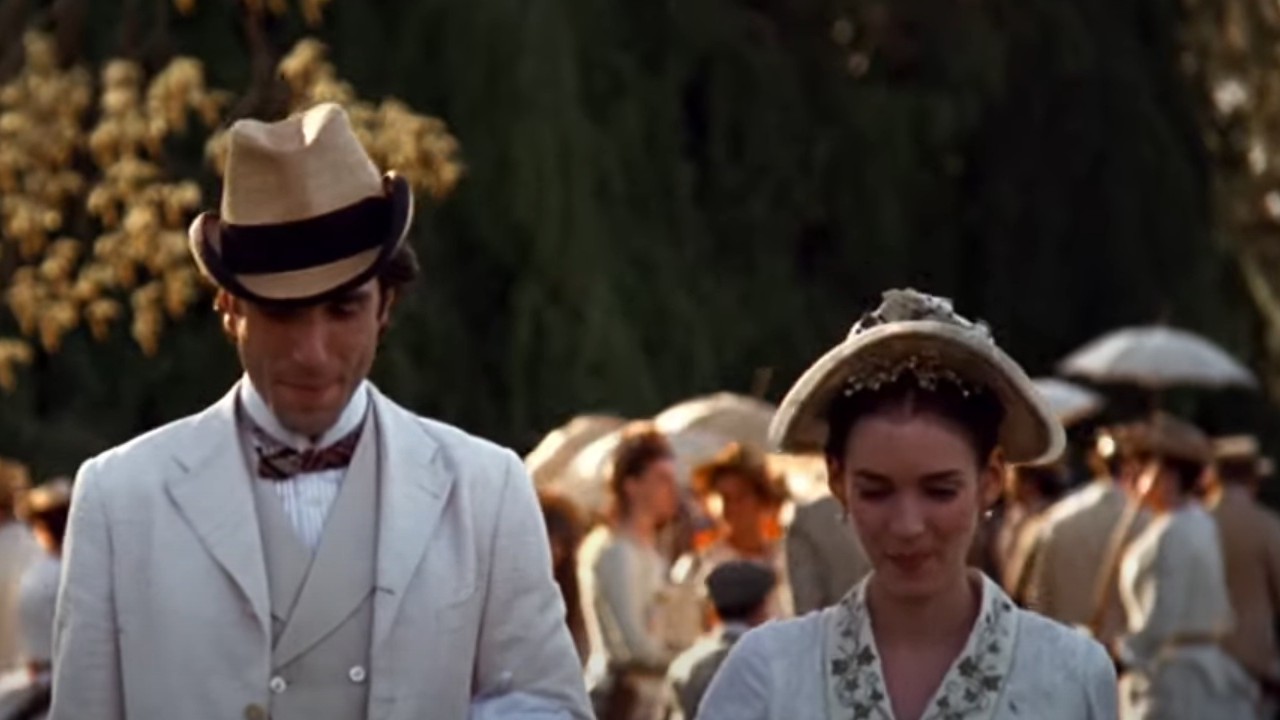 Daniel Day-Lewis walking with Winona Ryder while wearing white in The Age of Innocence