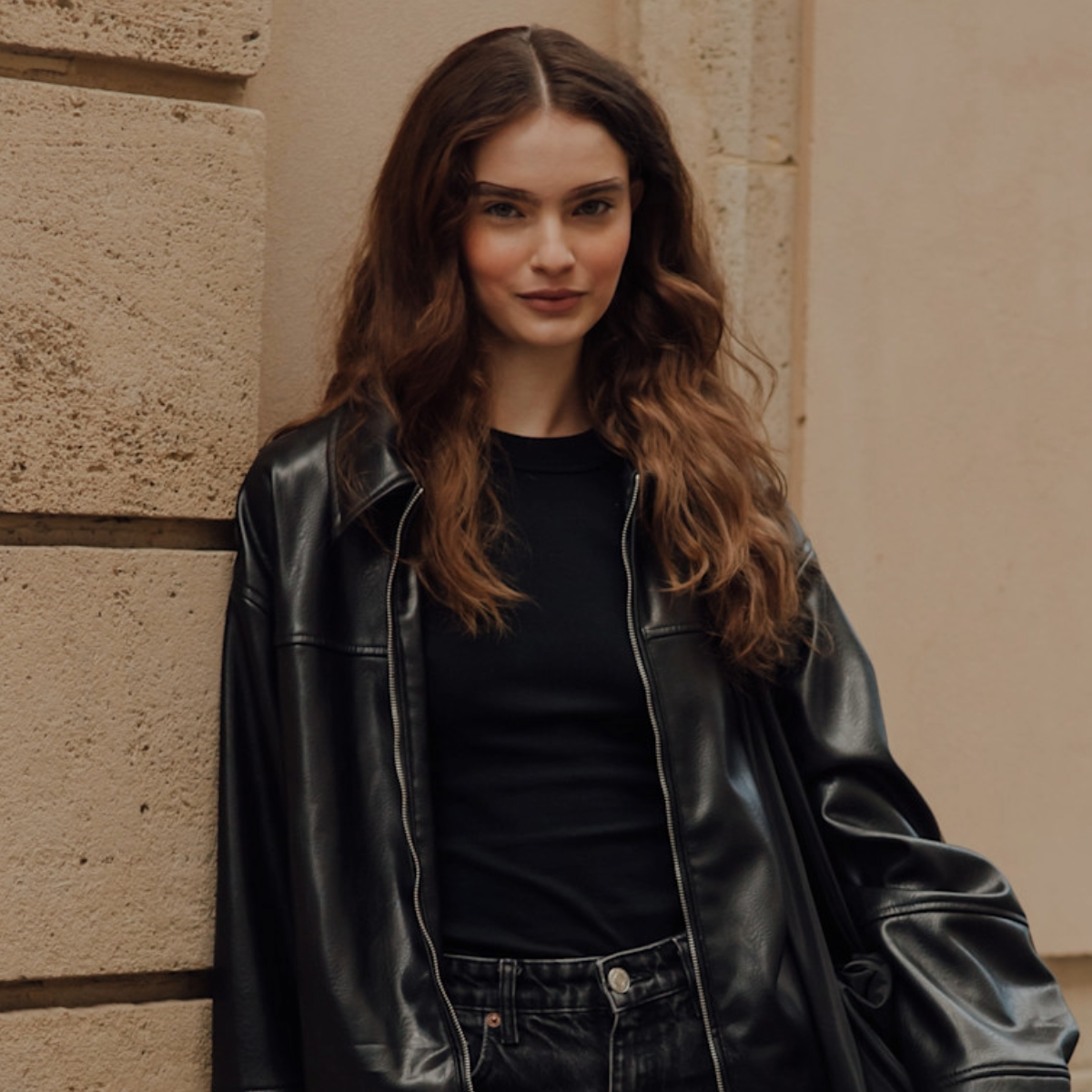 woman wearing a black leather jacket and black t-shirt .