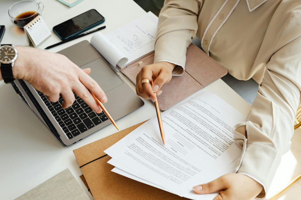 Two people reviewing legal documents sitting on a desk