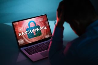 RAnsomware message on a computer screen with person sitting in front of it