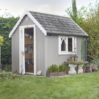 grey garden shed with white door and window