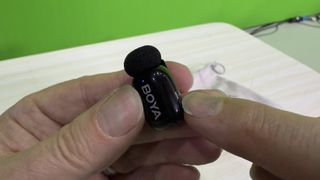 Boya Mini microphone held between two fingers