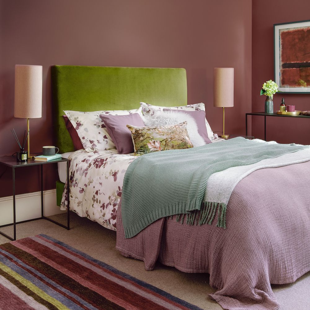 bedroom with plum wall and green headboard