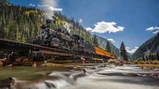 A low shooting angle of a steam train on the Durango and Silverton Narrow Gauge Railroad in Colorado, USA, highlights the spectacular scenery of the San Juan National Forest