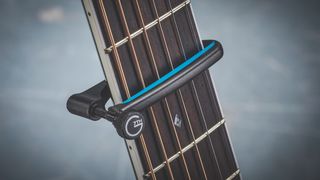 Close up of G7th capo on a guitar fretboard