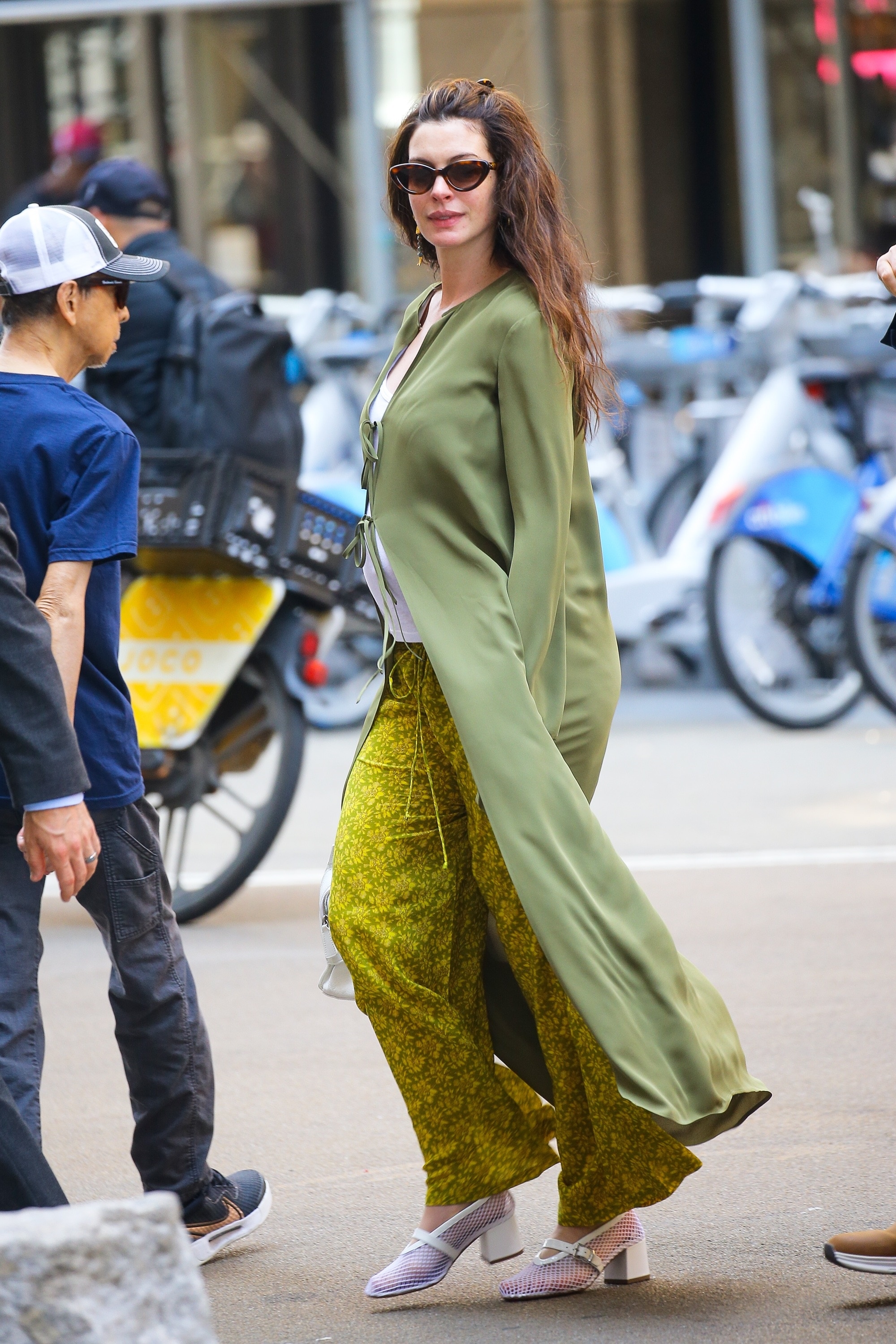 Anne Hathaway wears mesh heeled ballet pumps with floral trousers and a longline cardigan.