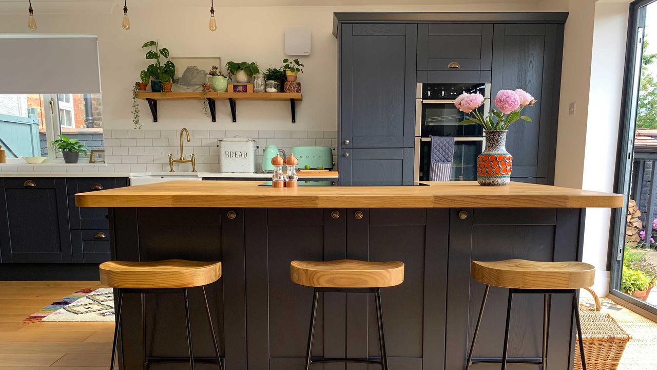 blue kitchen with island and bar stools, kettle and toaster 