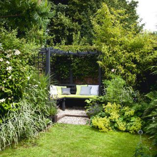 A covered garden seating area surrounded by plants