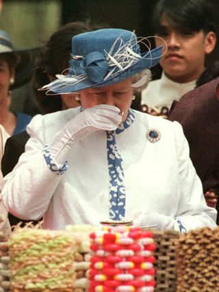 With a birthday feast of rice cakes and fruit in front of her, Britain's Queen Elizabeth drinks a cup of rice wine after being toasted on her birthday in the 400-year-old village of Hahoe, near the city of Andong April 21.