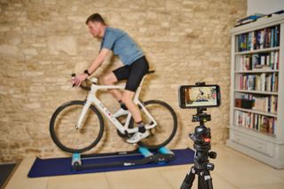 Simon Fellows filming himself riding on rollers for an AI bike fit with MyVeloFit