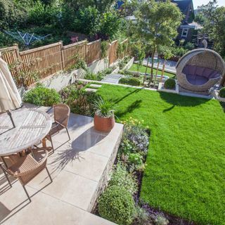 garden area with coffee table and chairs with plants and shrubs