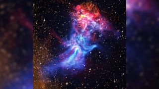 a red and blue cloud of gas on a starry background that resembles a human hand