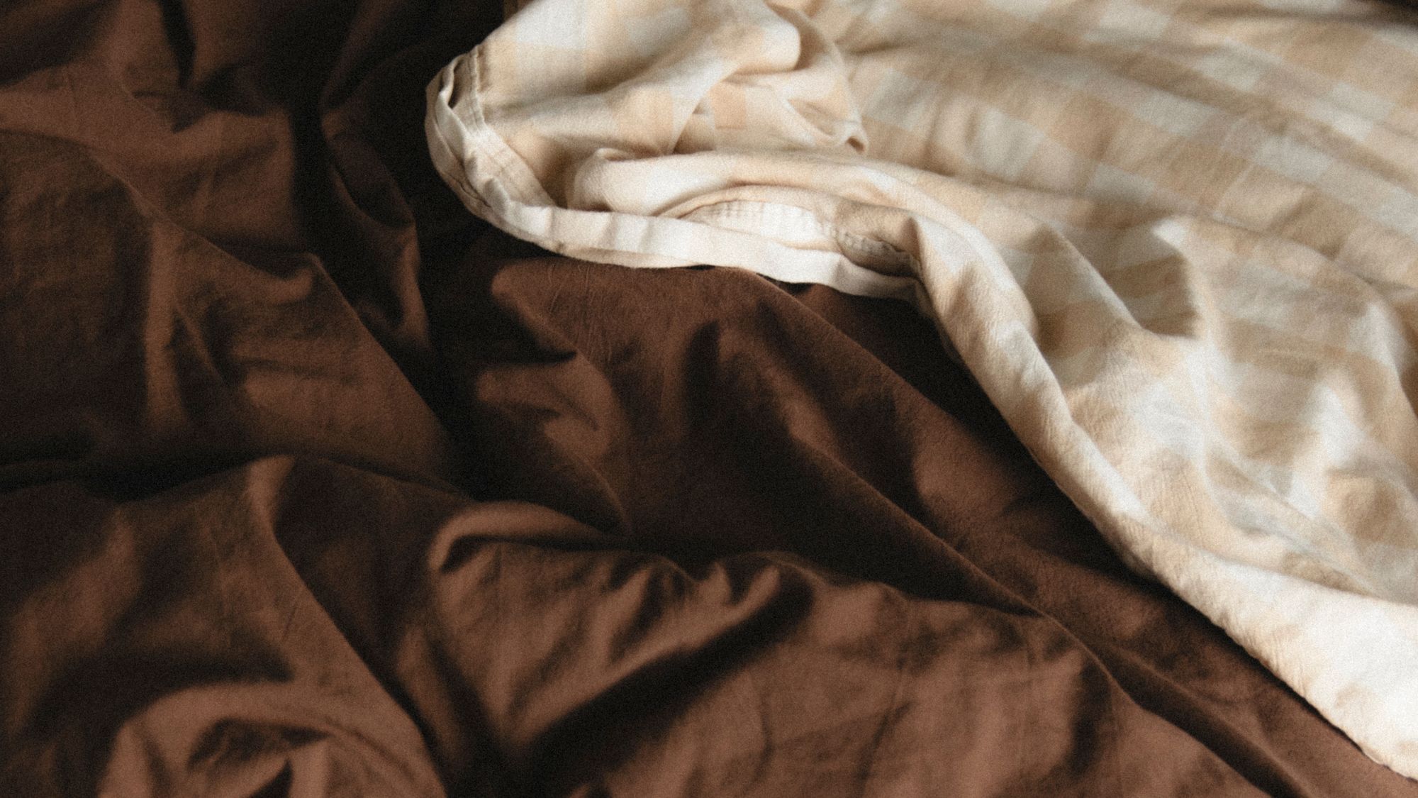 A chocolate brown duvet cover with gingham sheet