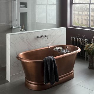 bathroom with grey wall and copper bathtub