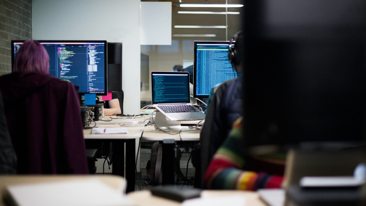 Three people in an office working on computers