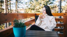 Young woman chills out with coffee on balcony
