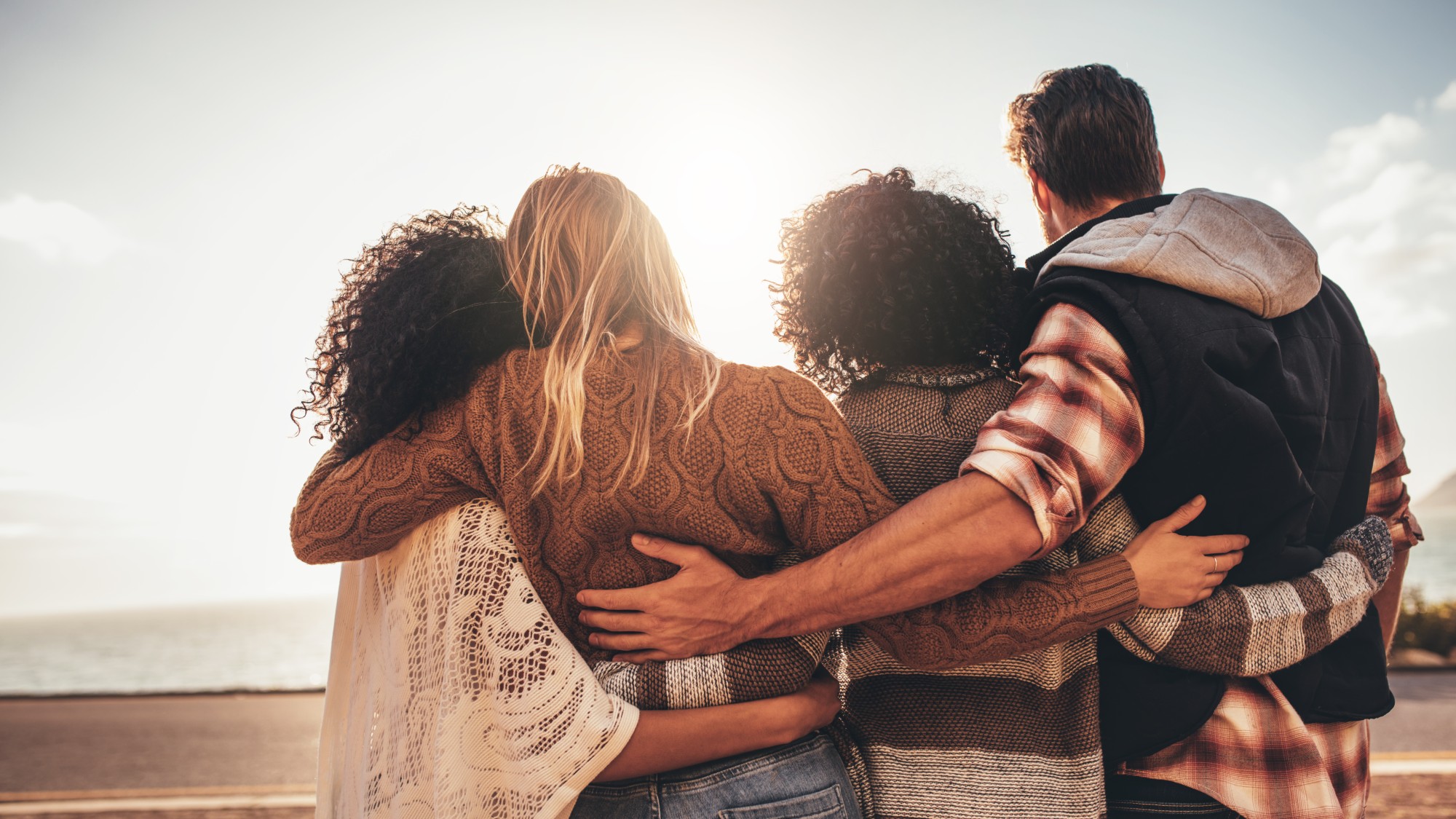 Rear view of four young people admiring a view.