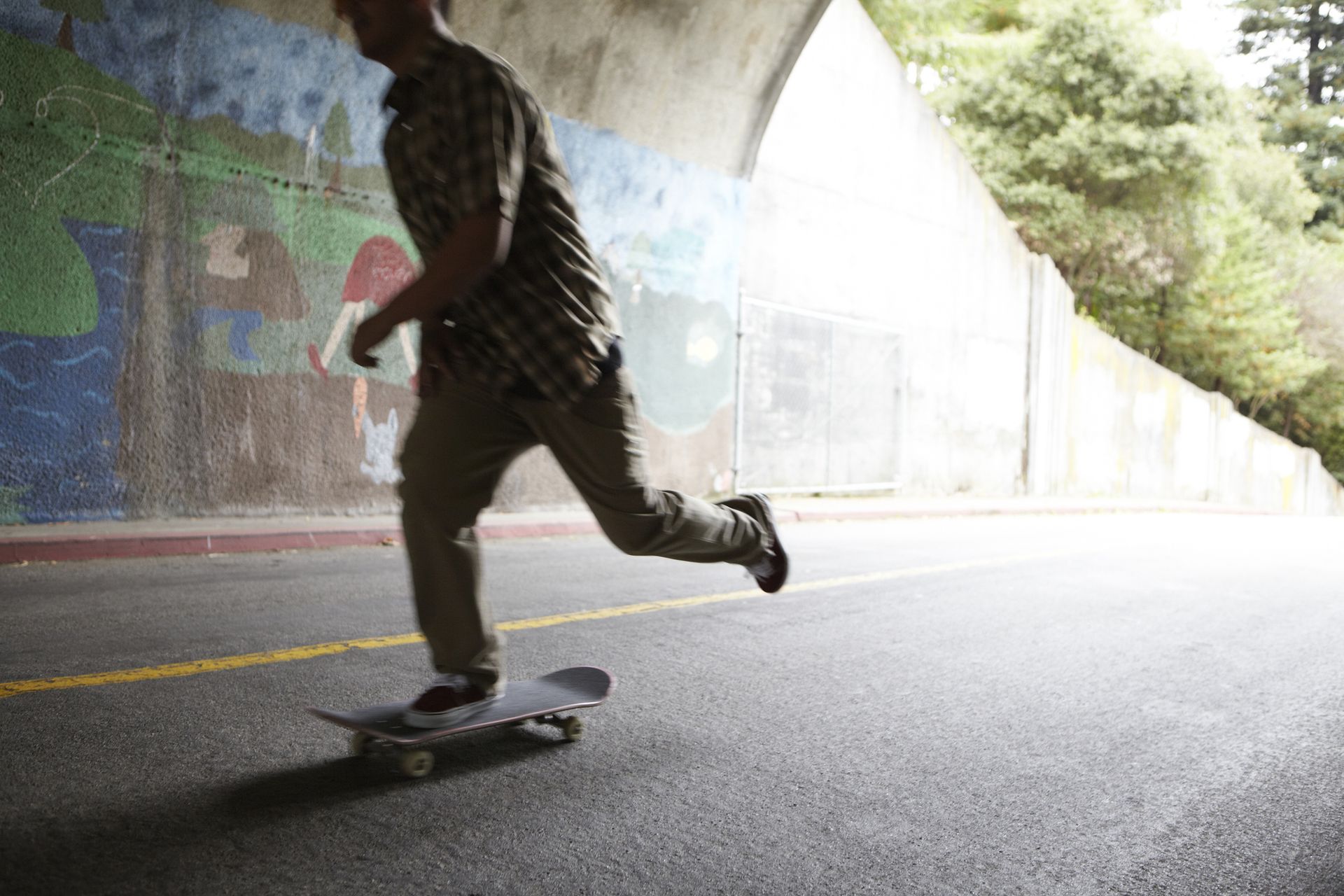 Young man skateboarding in a tunnel